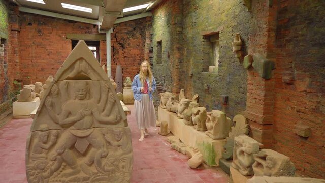 A young woman tourist is walking through ruins in the My Son Sanctuary, remains of an ancient Cham civilization in Vietnam.Tourist destination in the city of Danang. Travel to Vietnam concept