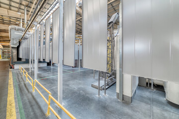 Powder coating line. Metal panels are suspended on an overhead conveyor line.