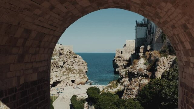 Flying under a bridge straight to the beach with rock coast nearby