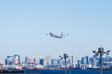 Fototapeta na wymiar 青空を背景に羽田空港を離陸する飛行機