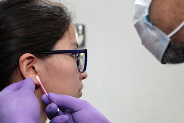 Perforación piercing en oreja lóbulo arete en estudio de tatuajes