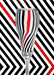 refraction of light by a wine glass on a black and white striped background. Abstract glass art.