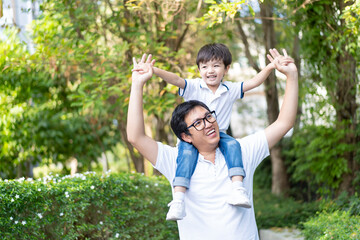 Obraz premium Happy Asian family concept, little happy young boy playing with his father at the garden