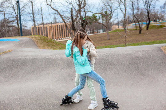 Preteen girl roller scating in the park after school in the rollerdome. Rest time for the child after school