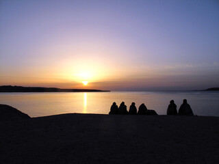 A group of people admiring the sunrise over the Red Sea