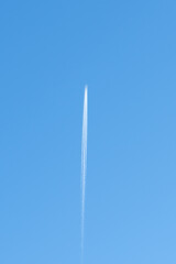 A condensation trail from an airplane in the sky. Close-up of 2 white footprints in a blue sky.