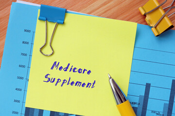 Financial concept meaning Medicare Supplement with inscription on the piece of paper. - obrazy, fototapety, plakaty