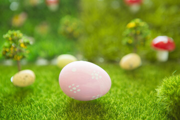 Little Easter bunny toys and Easter eggs on green grass. Fairy tale