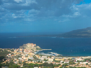 Fototapeta na wymiar Aerial view of the port of Calvi with dramatic sky. ​​Corsica, France. Tourism and vacations concept.