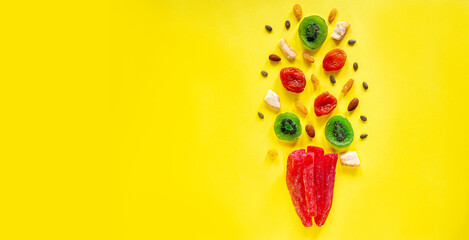 Composition of multicolored candied fruit on a yellow background. View from above. A place for text. Organic Vegan Sweets