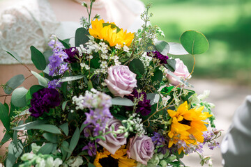 Pink, purple, yellow, white flower bouquet including sunflowers, roses, and babies breath
