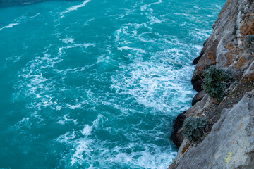 beautiful blue sea with big waves in a storm and rocks