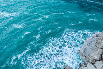 beautiful blue sea with big waves in a storm and rocks