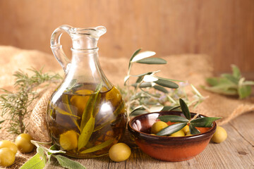 olive oil and leaves on wood background