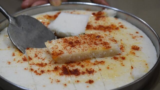 peeling and removing idli or square khaman from dish with spatula