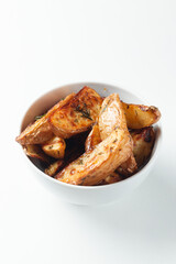 Bowl with tasty potato wedges on white isolated background.