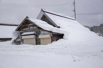 屋根雪の重みでで倒壊しそうな家