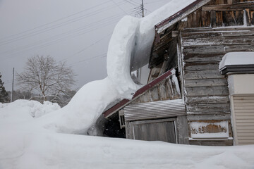 屋根雪の重みでで倒壊しそうな家
