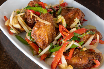 Chili chicken wings on a white plate