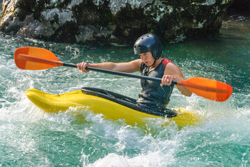 Junge Sportlerin paddelt kraftvoll im Wildwasser der Soca