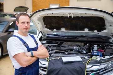 An auto mechanic does maintenance to the car.