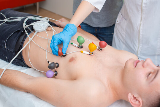 Cardiogram of the heart. The doctor attaches electrodes of an electrocardiograph to the patient&rsquo;s chest. Cardiology