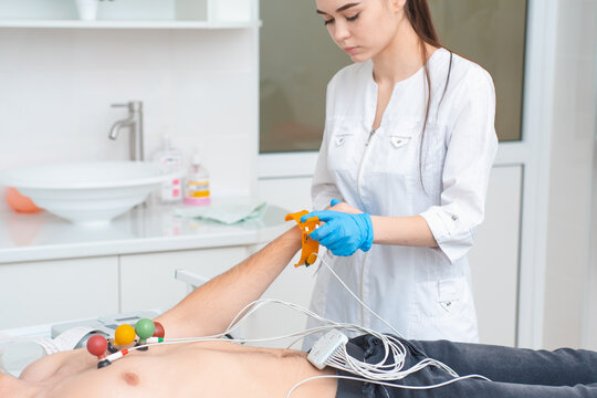Cardiogram of the heart. Cardiologist attaches electrodes of an electrocardiograph to a young man. Cardiology
