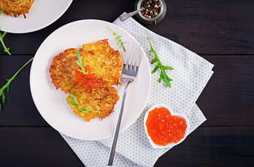 Fried potato pancakes with red caviar and sour cream, fritter, roesti. Traditional delicious food, lunch. Top view, flat lay