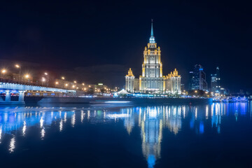 Moscow. Russia. Evening in the capital of Russia. Stalin's high-rise buildings in Moscow. The building of the hotel Ukraine against the dark sky. Reflection of buildings in the Moscow river.