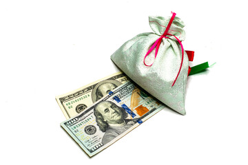 the bag symbolizing wealth lies on hundred dollar bills on a white background