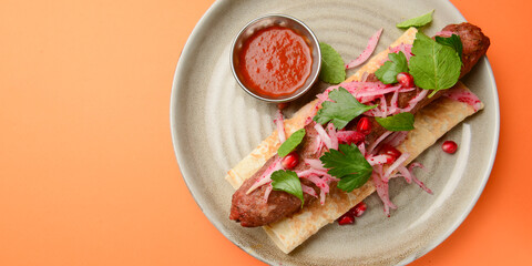 Tasty lavash rolls with sausages and vegetables, over orange background. Georgian cuisine concept.