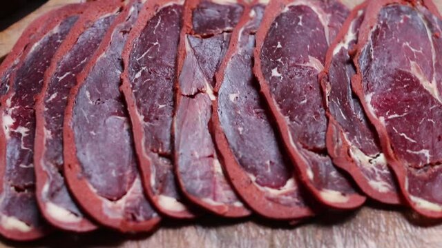 beef bacon sliced ​​on wood board. blurry background. traditional turkish food pastirma