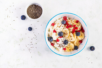 Cottage cheese with bananas, blueberries. Dietary breakfast for summertime. Top view, overhead, copy space
