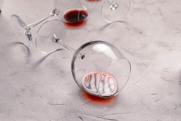 Wine glass laying on a textured background. Close up on with red wine, alcoholic beverage.