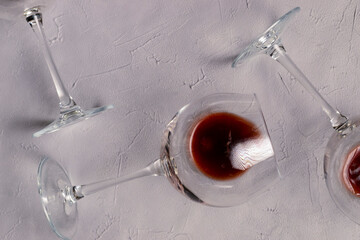 Wine glass laying on a textured background. Close up on with red wine, alcoholic beverage.
