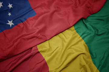 waving colorful flag of guinea and national flag of Samoa .
