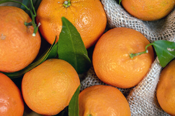 tangerines with leaves on a texture bag