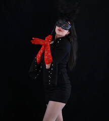 studio portrait of a beautiful girl with a theatrical mask on a black background