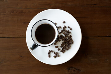 Coffee Cup On Roasted Coffee Beans wood table