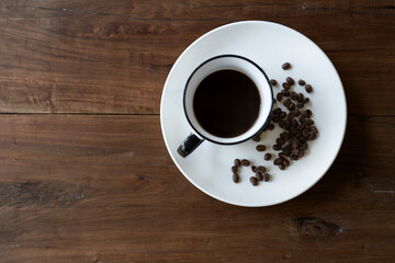 Obraz na płótnie Canvas Coffee Cup On Roasted Coffee Beans wood table