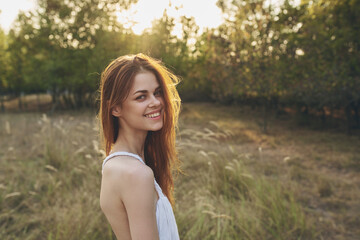 Naklejka premium happy traveler in a field among tall trees and dry grass model vacation