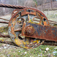 An element of an old rusty steel cable, secured with a special clip and block for lifting...