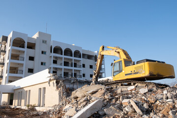 Crawler excavator working for the demolition of an old hotel. Excavator at construction side.