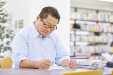 図書館で調べるものする男性