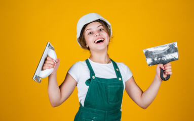 kid with helmet holding spatula. kid bricklayer masonry worker with helmet and trowel putty knife....