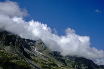 dense white clouds on the top of wonderful mountains and sky