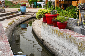red pots with flowers on the waterfront canal