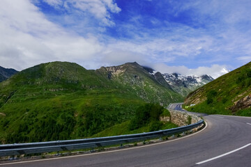 Fototapeta premium high curvy road in green mountains with blue sky