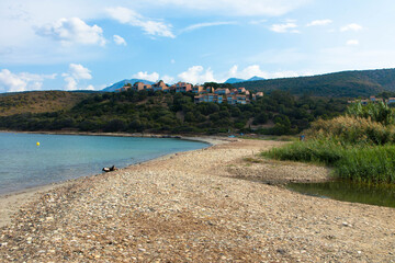 Beautiful natural beach called Plage D'Orzo with   a holiday resort in the background, near St. Florent. Corsica, France. Tourism and vacations concept.