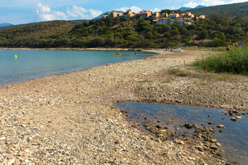 Beautiful natural beach called Plage D'Orzo with   a holiday resort in the background, near St. Florent. Corsica, France. Tourism and vacations concept.